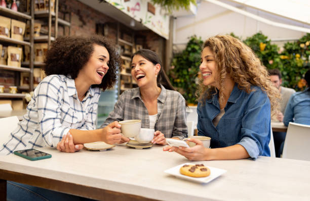 Happy group of women having fun talking at a coffee shop Happy group of Latin American women having fun talking at a coffee shop and laughing female-friendship stock pictures, royalty-free photos & images
