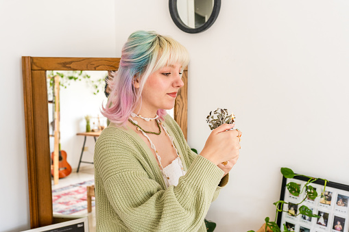 Young woman burns sage to remove negative energy