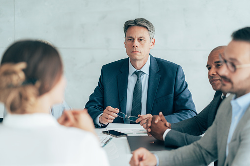 Five company directors in meeting with CEO in conference room.