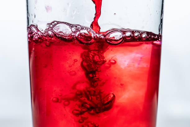 istock Red liquid being poured into a glass. White background... 1482461515