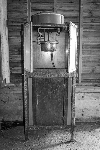 Old popcorn machine stands in an abandoned industrial building.