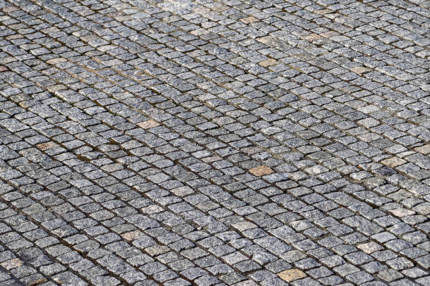 istock An old stoneblock pavement cobbled with granite blocks. Photo in perspective with selective focus 1482469395
