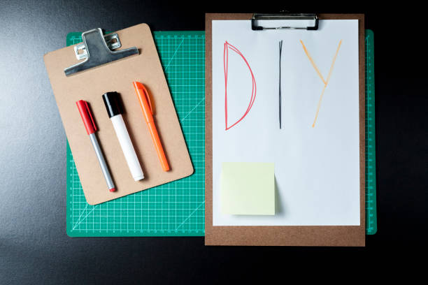 istock Handmade products cutting base with diy writing. Clipboard, papers, cardboard, scissors and colored adhesive. 1482474569