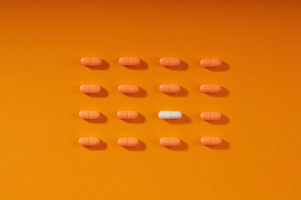 istock Pills in a row on orange background 1482475578