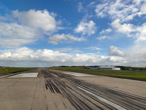 a view from the window of a landed commercial flight of the main runway of Leeds Bradford international airport in Yorkshire, England UK showing tyre marks from landing aeroplanes
