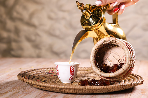 Arabic coffee with dates served with teapot in cup isolated on background top view ramadan food