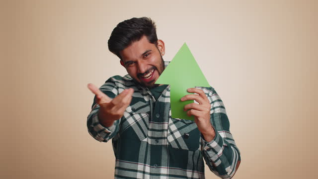 Indian man winner holding arrow sign pointing up, career growth and money increase good progress