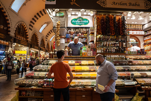 Picture of a stall of a merchant and shop in the egyptian bazaar of Istanbul, Turkey selling spices and other turkish food. The Spice Bazaar in Istanbul, Turkey is one of the largest bazaars in the city. Located in the Eminönü quarter of the Fatih district, it is the most famous covered shopping complex