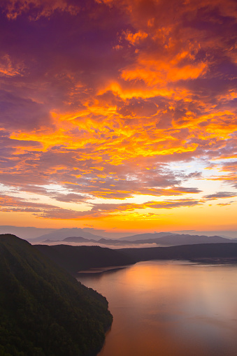 Dramatic sky of a mountain lake at dawn. Lake Mashu in Hokkaido, Japan.