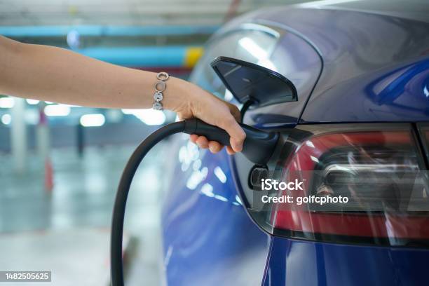 Woman Charging The Ev Car Stock Photo - Download Image Now - Charging, Speed, Adults Only