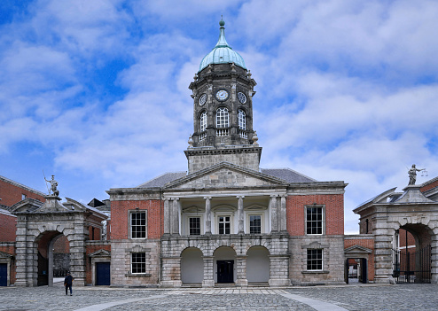 Dublin, Ireland - March 2023: Dublin Castle, clocktower and gatehouse viewed from cobblestoned courtyard