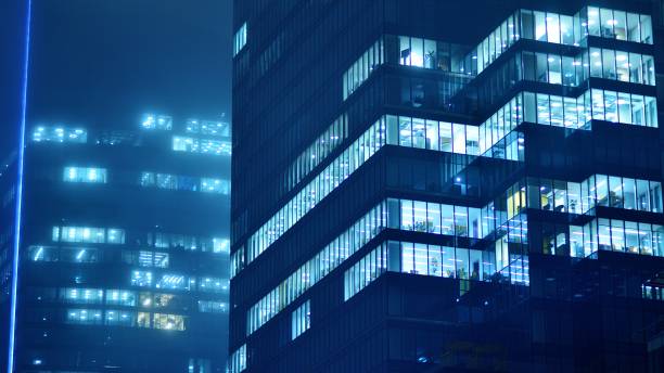 istock Pattern of office buildings windows illuminated at night. 1482519646