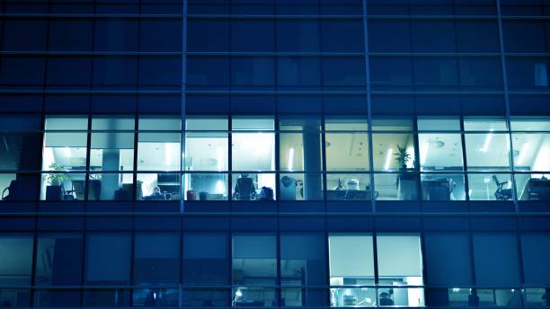 istock Pattern of office buildings windows illuminated at night. 1482519679