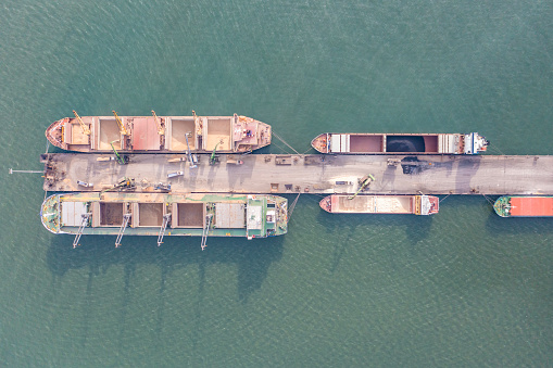 Cars export terminal in export and import business and logistics. Shipping cargo to harbor. Water transport International. Aerial view and top view.