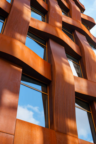 The brown facade of a stylish business building with modern architecture with a grid pattern against a blue sky.
