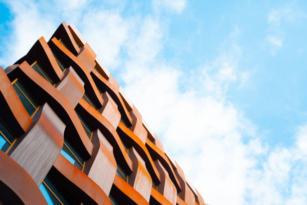 The brown facade of a stylish business building with modern architecture with a grid pattern against a blue sky.