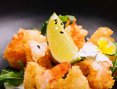 fried crispy shrimp on black plate`