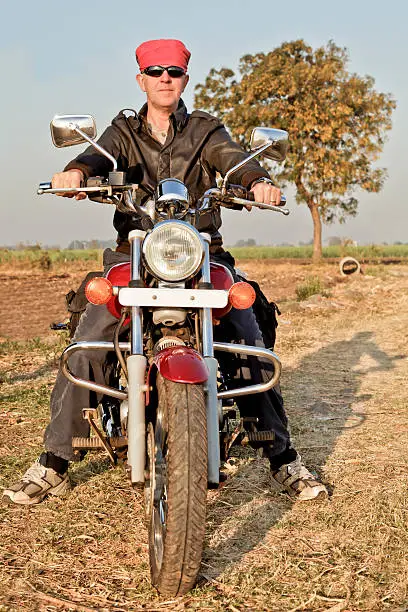 portrait of an european biker with headgear in the farmlands and hinterlands of Gujarat, India
