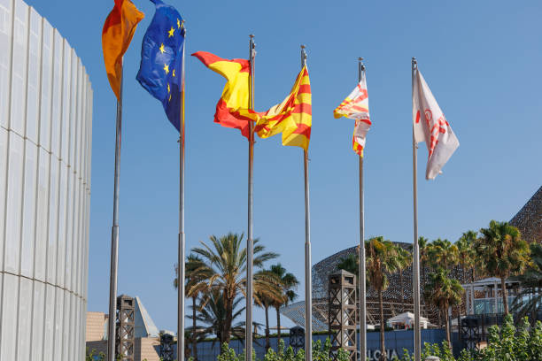 Barcelona, Spain - august 2022: Flags waving against Blue Sky Outside Public Building.