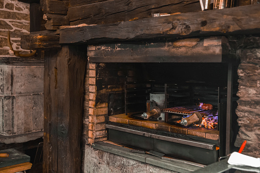 Fresh meat cooking in wood fired oven at restaurant kitchen