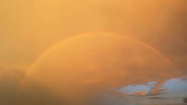 Amazing panoramic view of blurry rainbow on beautiful summer dramatic twilight sky background.Image use for natural environment presentation backdrop.