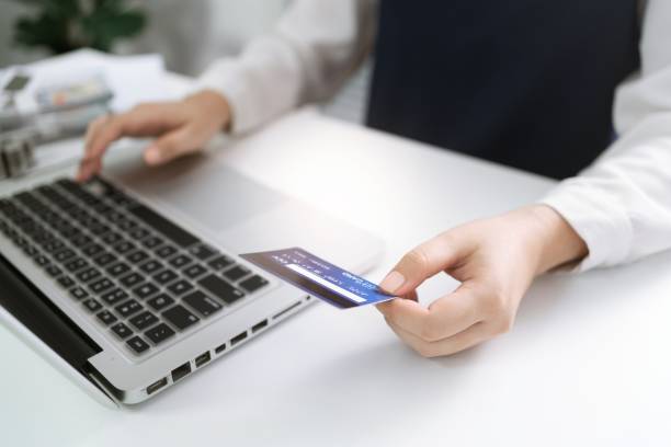istock Woman holding credit card and using laptop computer for Internet online e-commerce shopping spending money Online shopping laptop technology concept . Online shopping pay by credit card concept 1482546477