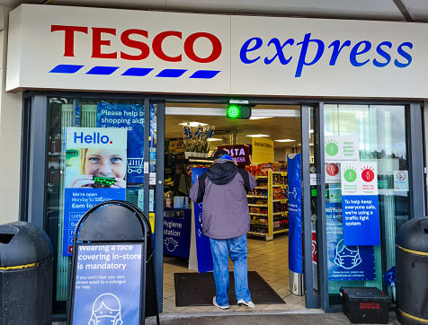 London. UK- 01.29.2021. The name sign and entrance of a branch of Tesco Express grocery supermarket.