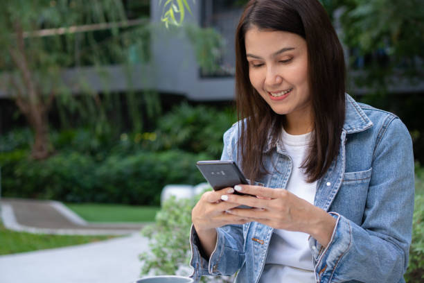 istock Young asian woman freelancer holding smartphone and reading text message and surf wireless internet on smartphone. Shopping online on a smartphone. Lifestyle women working at home concept. 1482550087