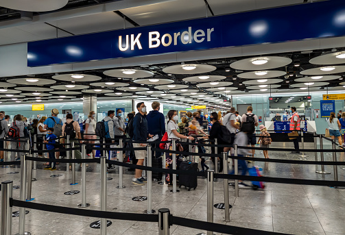 Heathrow Airport. UK- 08.08.2021: the UK Borders  in Terminal 5 with arriving internation travel passengers waiting for immigration control and passport check.