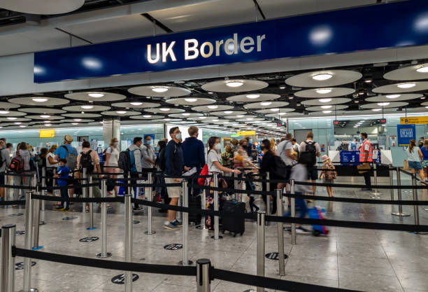 the UK Borders  in Terminal 5 with arriving internation travel passengers waiting for immigration control and passport check. Heathrow Airport. UK- 08.08.2021: the UK Borders  in Terminal 5 with arriving internation travel passengers waiting for immigration control and passport check. heathrow airport stock pictures, royalty-free photos & images