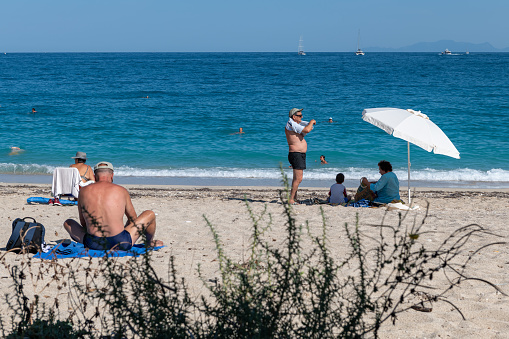 Lefkada island. Greece-08.06.2021: tourists relaxing and sun bathing on a beach.