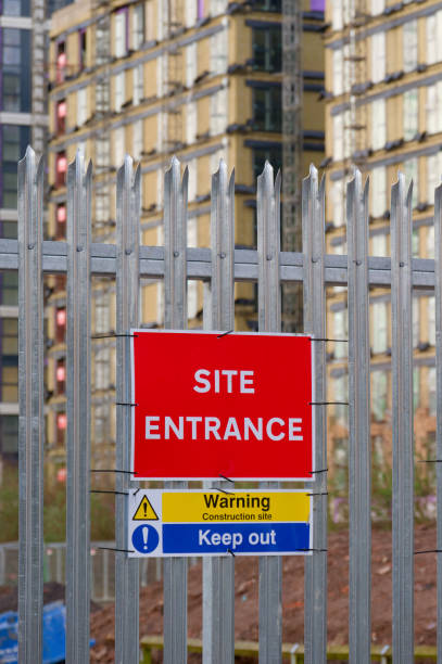 istock Site entrance sign on fence boundary at construction site 1482551894