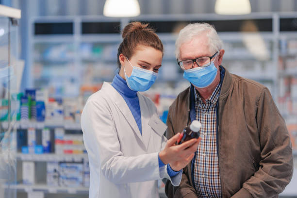 istock Young pharmacist helping senior man to choos medication. 1482556985