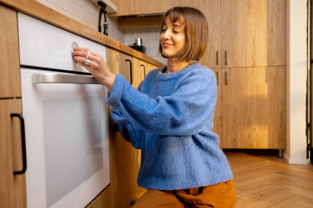 istock Woman using an oven at new kitchen 1482557618