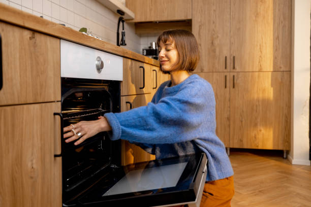 istock Woman opens an oven on kitchen 1482559425