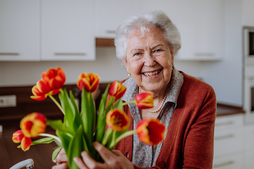 Portrait of senior woman with bouquet of flowers.