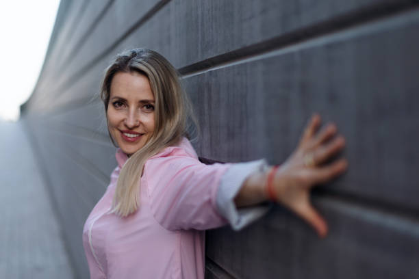 istock Young blond woman standing in front of concrete wall. 1482561231