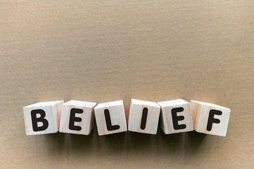 BELIEF alphabet letter with toy block on paper background.