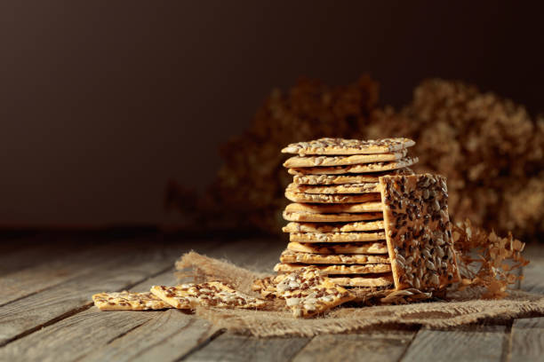 istock Crackers with sunflower and flax seeds on an old wooden table. 1482562730