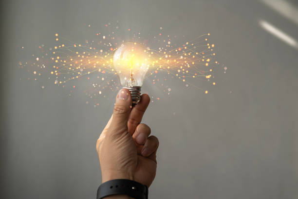 istock Businessman holding glowing lightbulb with orange light . Creative new business idea concept. 1482563931