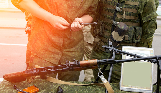 Light machine gun on the table. The soldiers are considering Russian-made weapons.