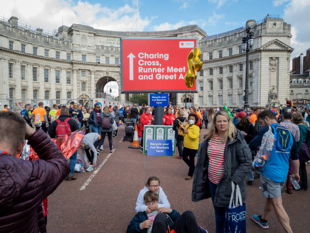 famiglie e amici salutano i corridori sul pall mall alla fine della maratona di londra. - london marathon foto e immagini stock