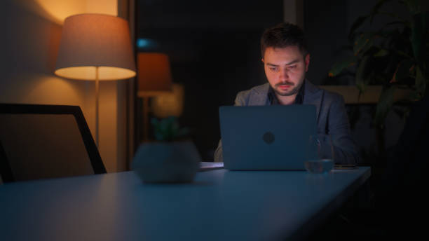 istock Businessman working alone in office at night 1482570568