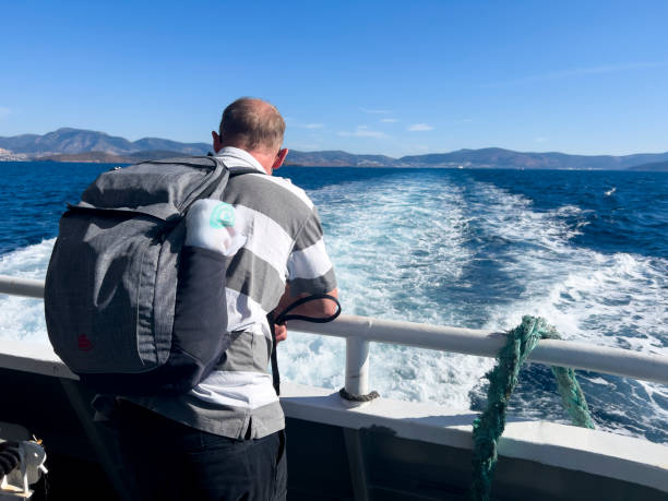 istock Lonely man standing at stern railing, rear view 1482573870