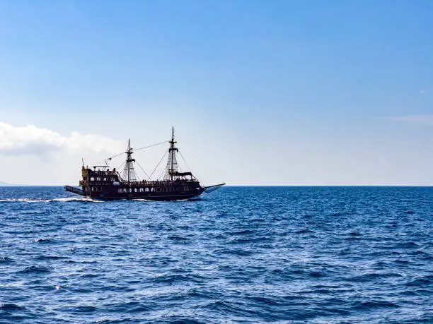 Travel destination concept: Beautiful seascape - view of morning sea with tourist sightseeing ship. Blue sky and sea background with copy space.