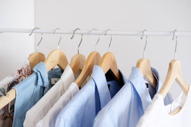 istock Men's and women's clothing hangs on hangers in white protective covers 1482577653
