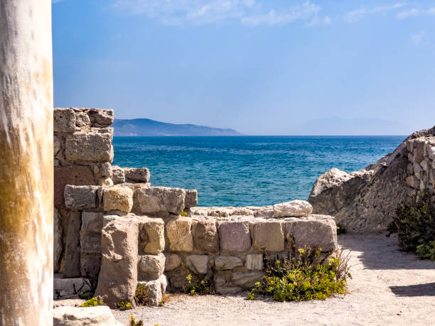 Ruins of Agios Stefanos: The ruins of the Basilica Àgios Stéfanos are located at Kefalos, Kos Island, Greece. Early Christian basilica built between 496 and 554 AD. History travel destination concept with blue sky background, copy space.