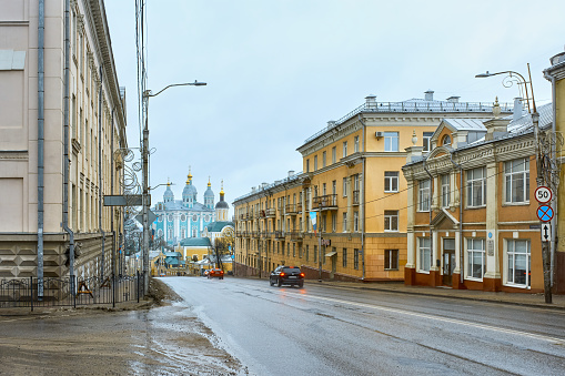 Cityscape of the street, old residential buildings and road with cars in the historical center of St. Petersburg, Russia. Unrecognizable people on the sidewalk, summer sunny day