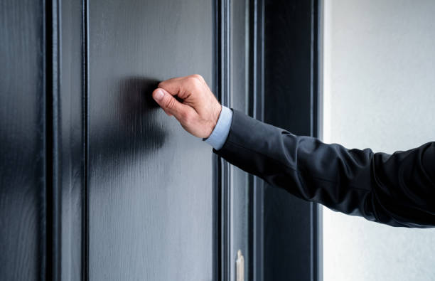 Close up of young man knocking on the door stock photo