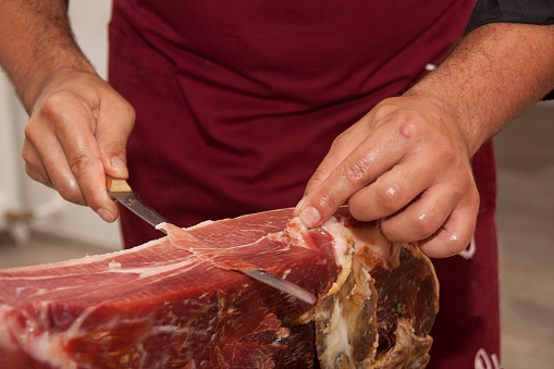 Cutting slices of cured ham, typical 